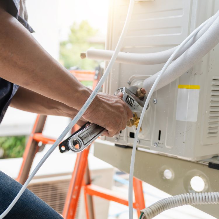 فني تكييف يثبت مكيف جداري سبليت في منزل بالرياض